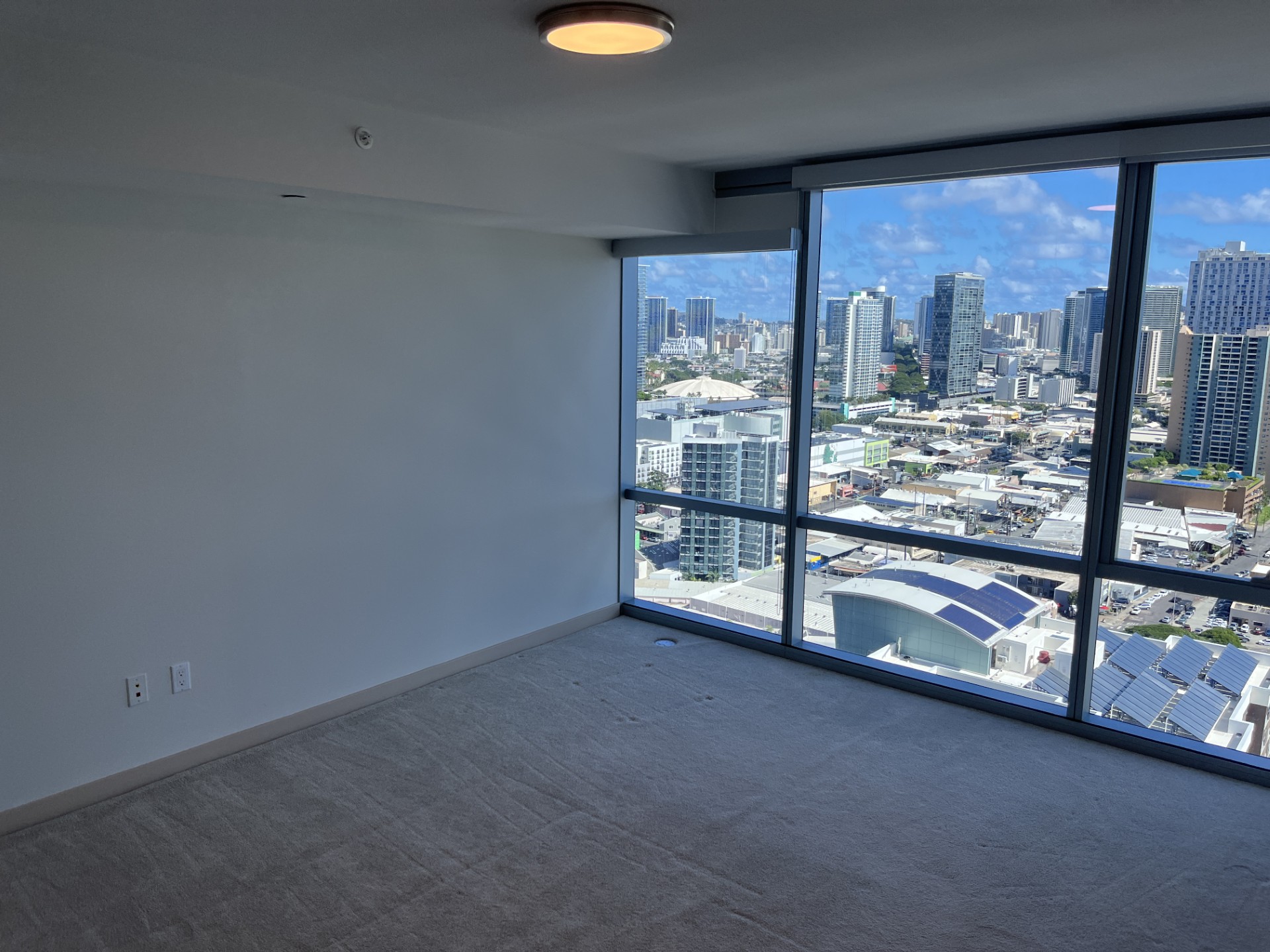 A room with a large window overlooking a cityscape.